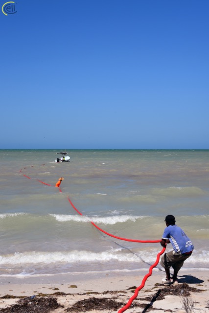 Man pulling cable across water
